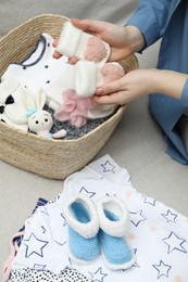 Photo of Woman with baby clothes on sofa at home, closeup