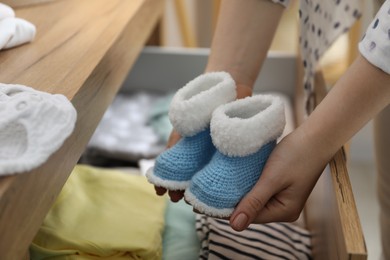 Photo of Woman with baby booties at home, closeup