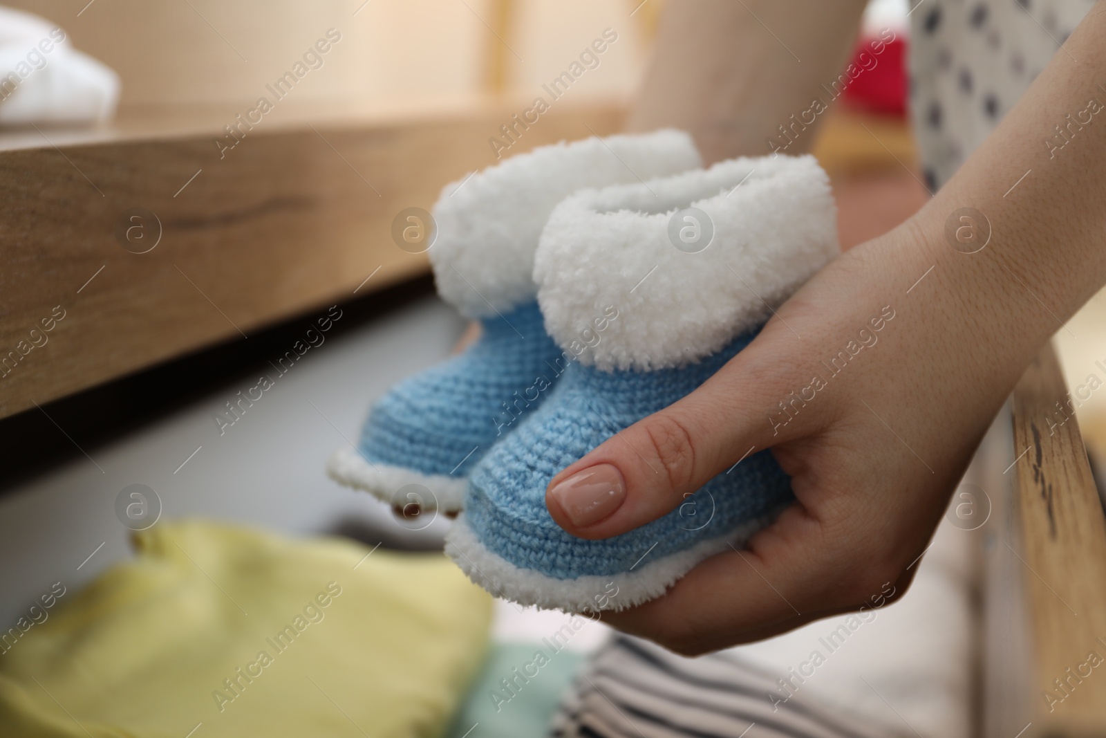 Photo of Woman with baby booties at home, closeup