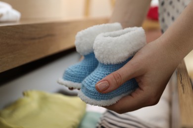 Photo of Woman with baby booties at home, closeup