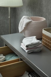 Photo of Baby clothes on gray chest of drawers indoors