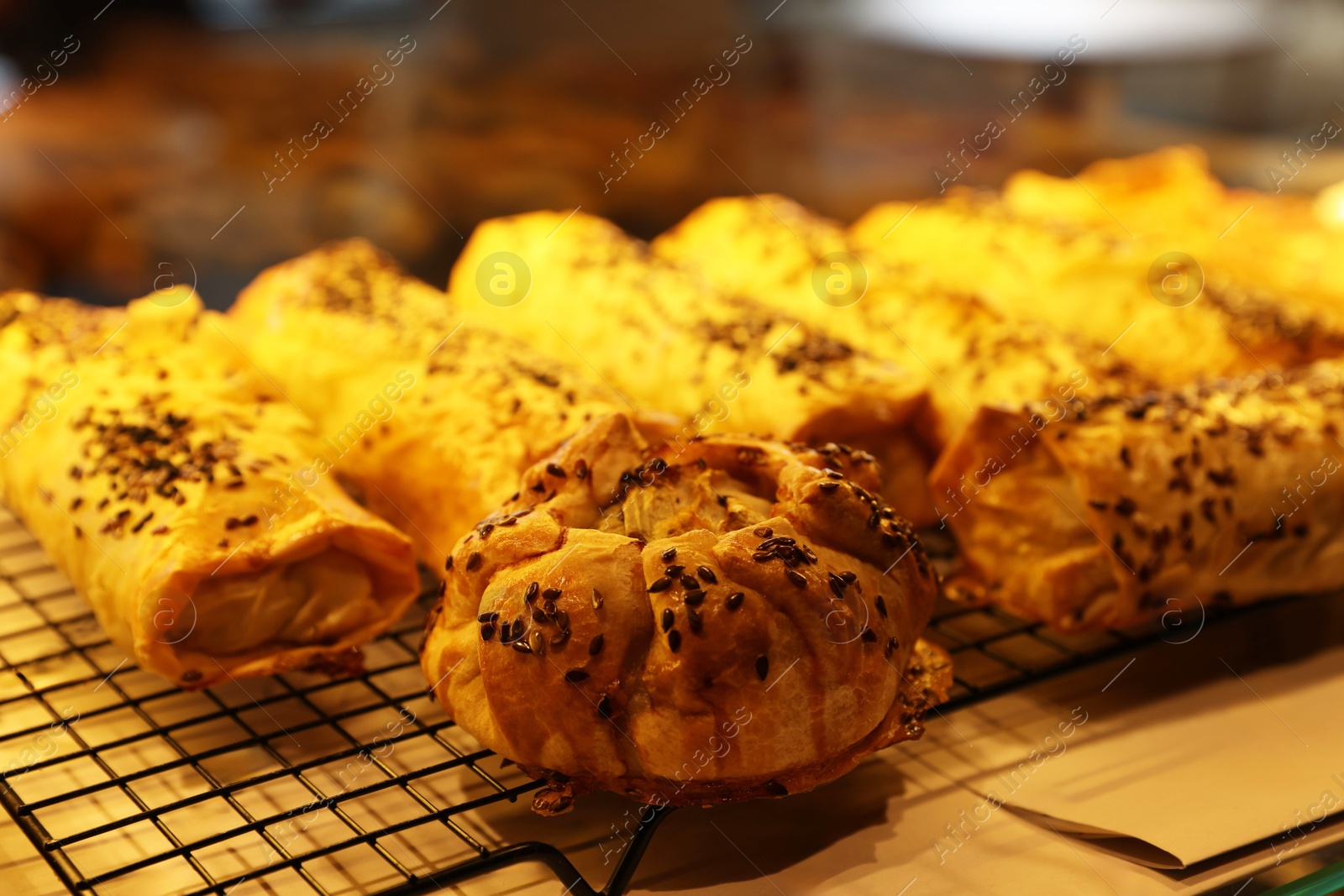 Photo of Tasty puff pastries on display in cafe, closeup