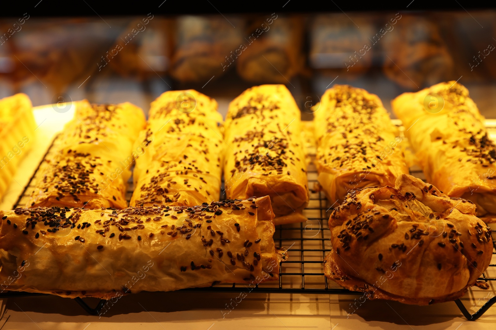 Photo of Tasty puff pastries on display in cafe, closeup