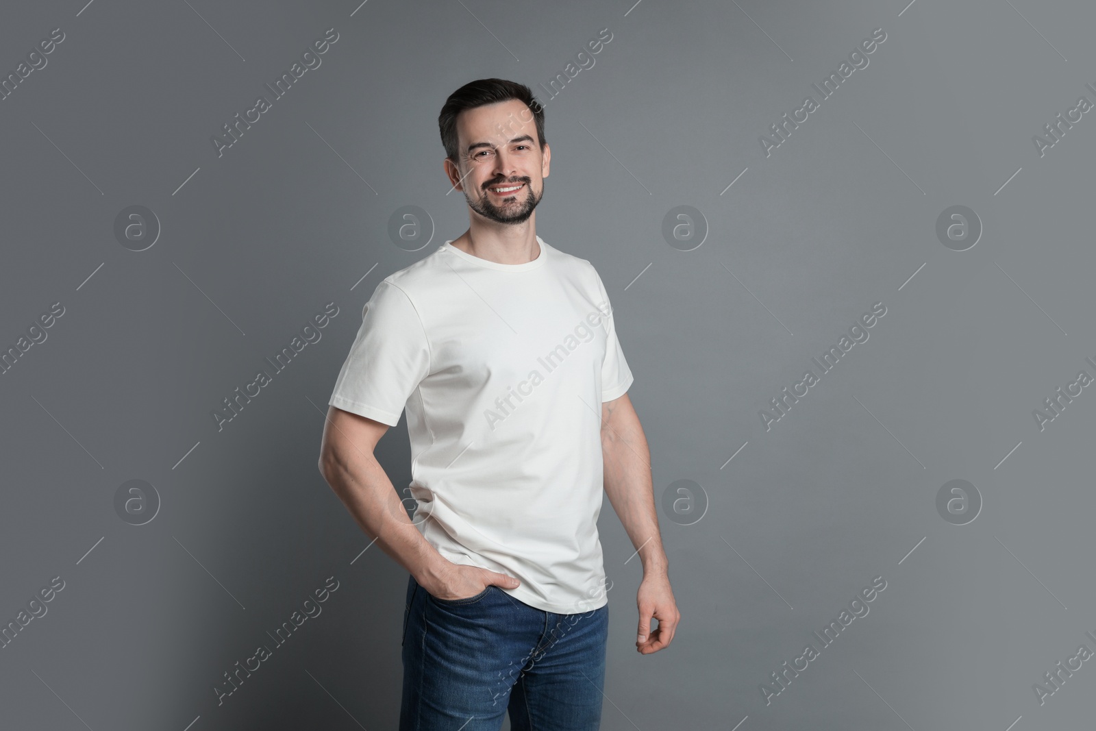 Photo of Man in blank white t-shirt on grey background. Mockup for design