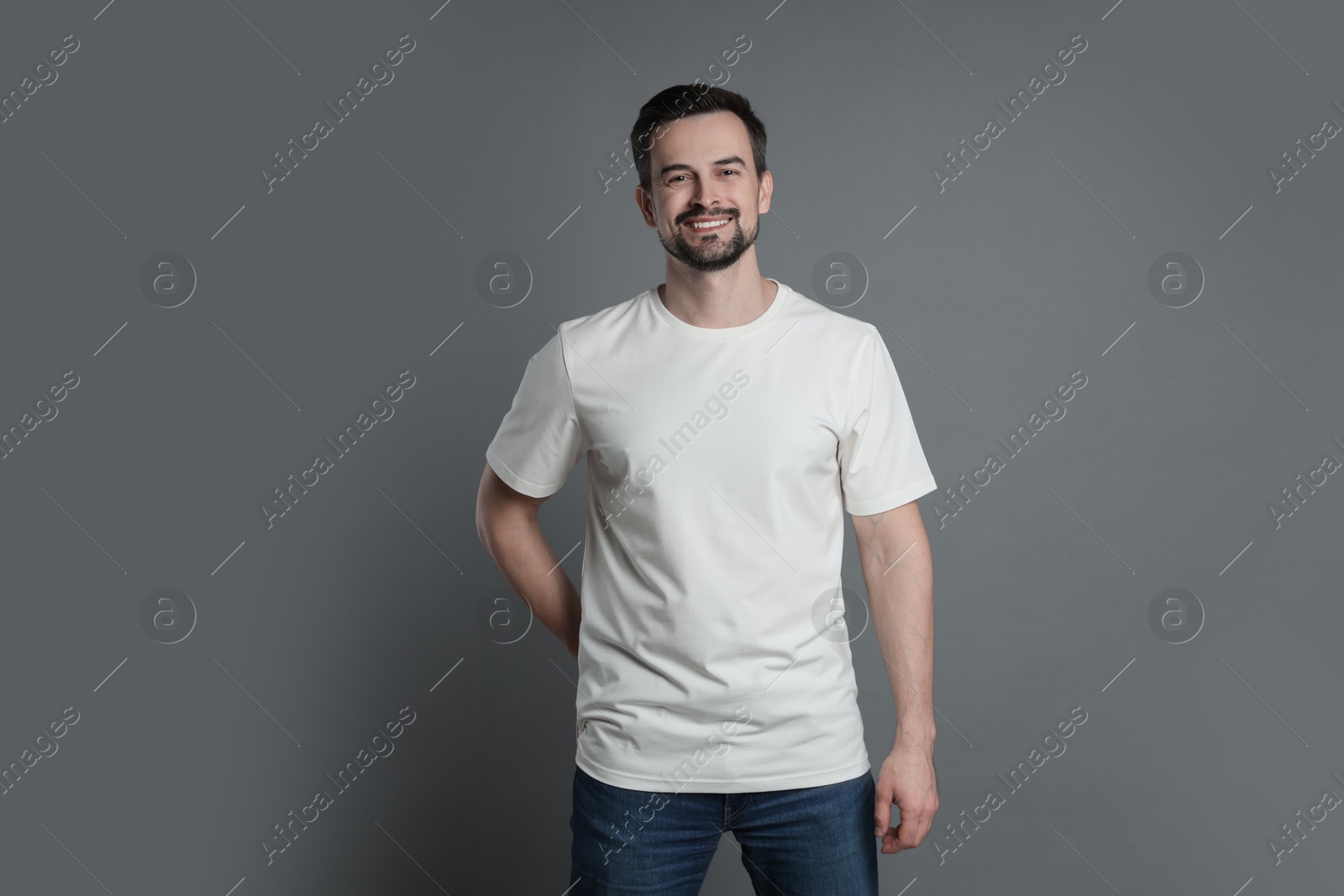 Photo of Man in blank white t-shirt on grey background. Mockup for design