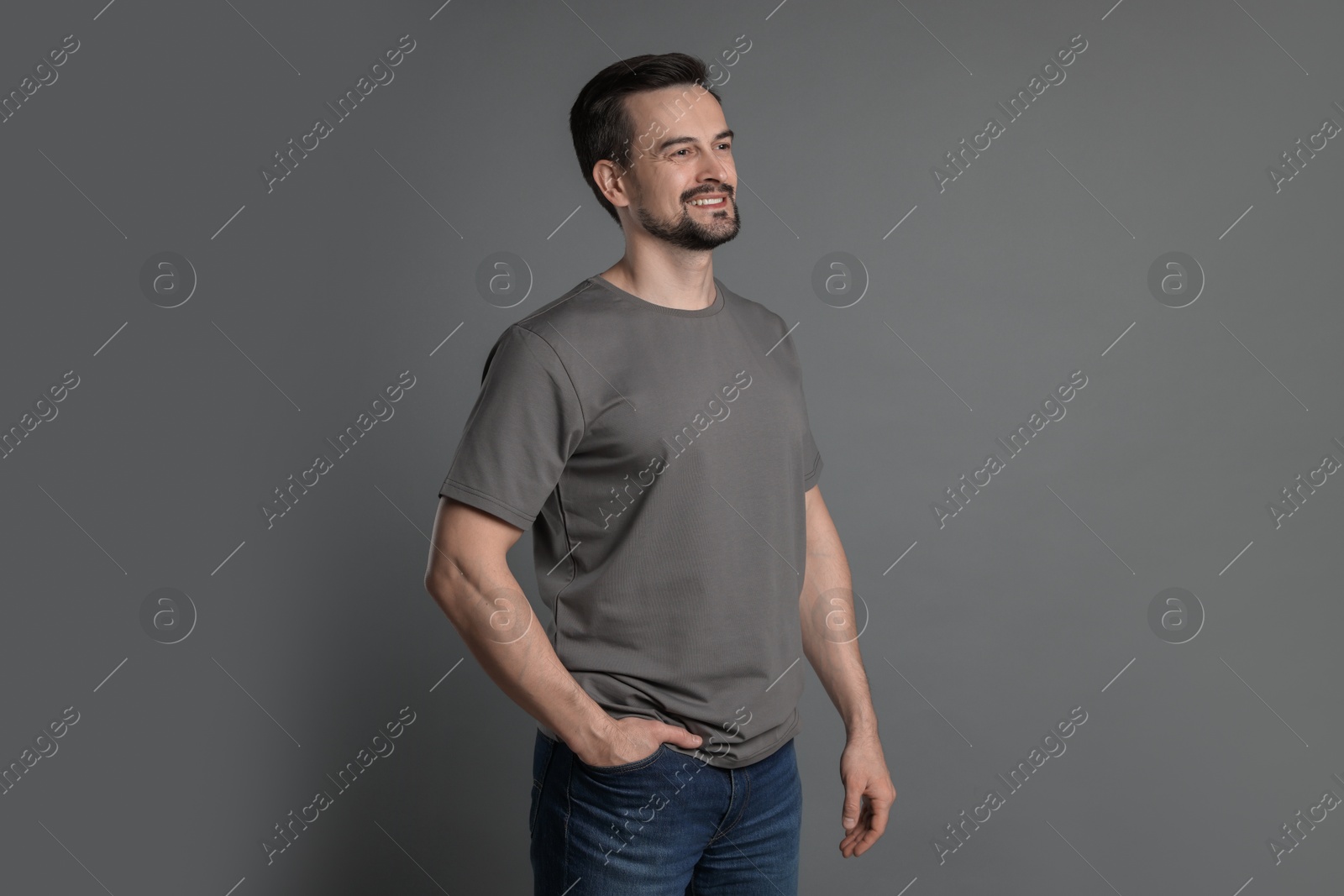 Photo of Man in blank t-shirt on grey background. Mockup for design