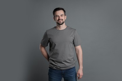 Photo of Man in blank t-shirt on grey background. Mockup for design