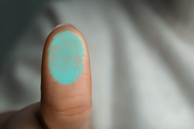 Image of Woman pressing finger to surface showing friction ridges pattern, closeup. Scanning fingerprint