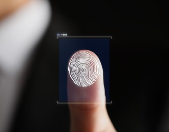 Image of Man pressing finger to surface showing friction ridges pattern, closeup. Scanning fingerprint