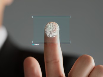 Image of Man pressing finger to surface showing friction ridges pattern, closeup. Scanning fingerprint