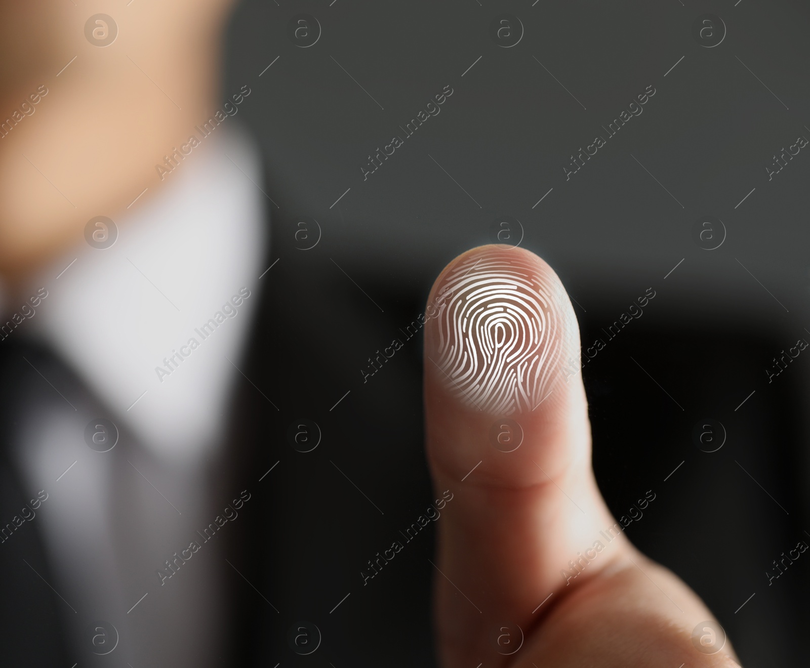 Image of Man pressing finger to surface showing friction ridges pattern, closeup. Scanning fingerprint