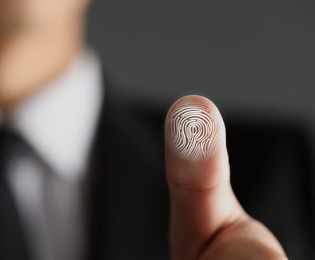 Image of Man pressing finger to surface showing friction ridges pattern, closeup. Scanning fingerprint