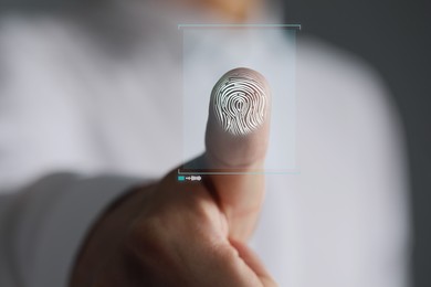 Image of Man pressing finger to surface showing friction ridges pattern, closeup. Scanning fingerprint