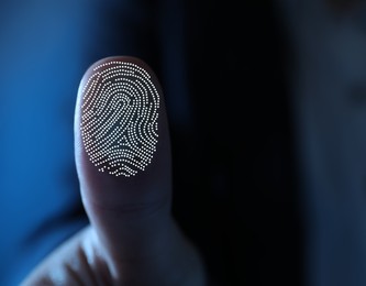 Image of Woman pressing finger to surface showing friction ridges pattern, closeup. Scanning fingerprint