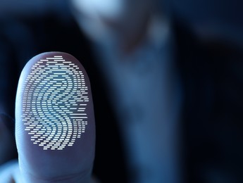 Image of Woman pressing finger to surface showing friction ridges pattern, closeup. Scanning fingerprint