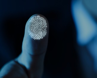 Image of Man pressing finger to surface showing friction ridges pattern, closeup. Scanning fingerprint