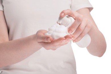 Photo of Woman applying cleansing foam onto hand on white background, closeup