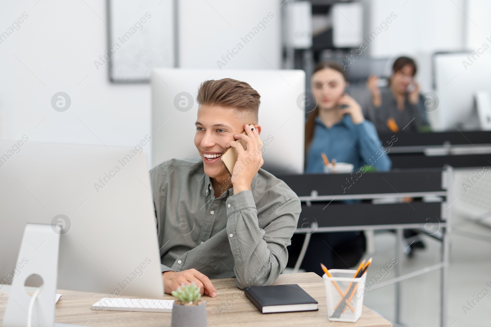 Photo of Salesman talking on phone at desk in office