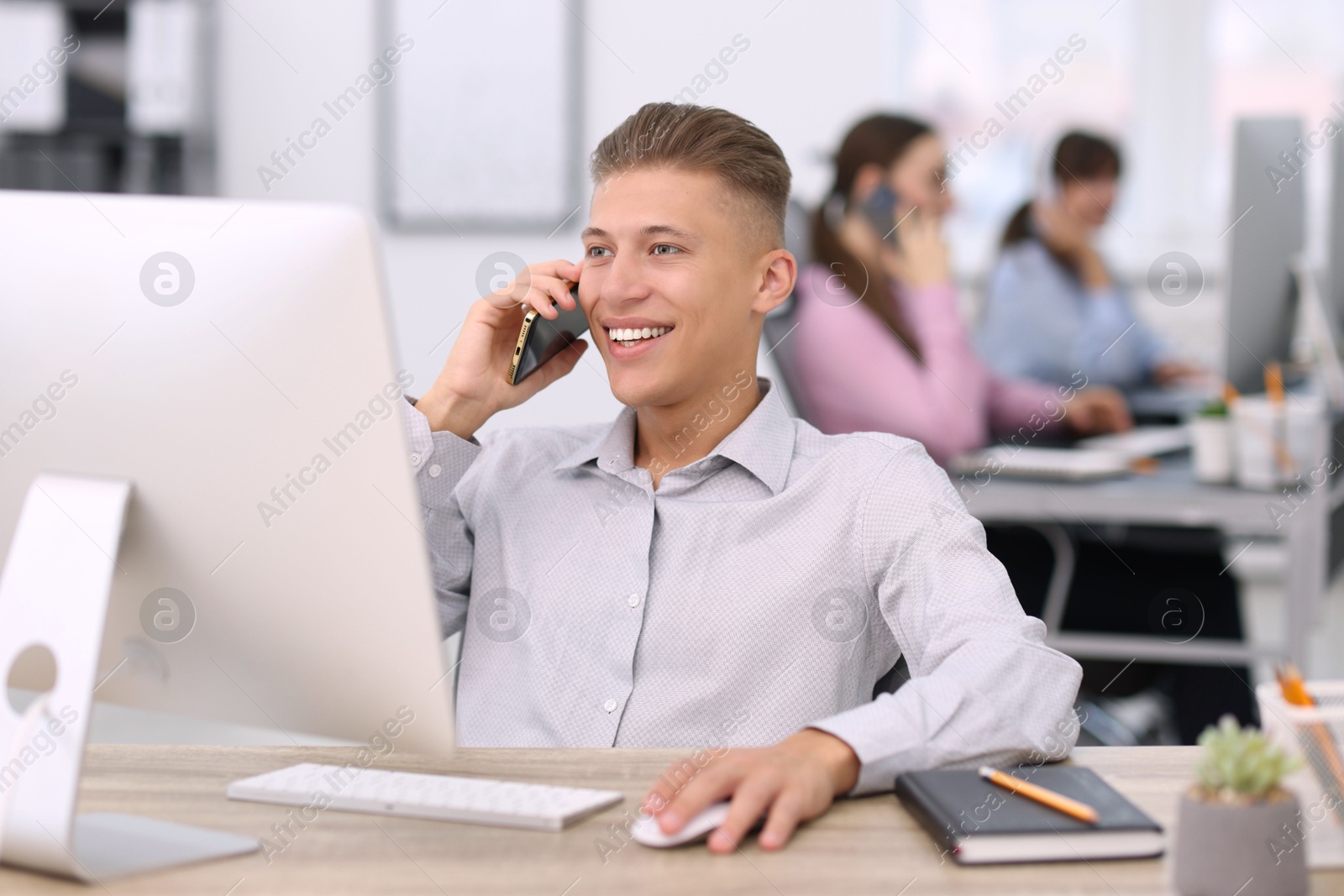 Photo of Salesman talking on phone at desk in office