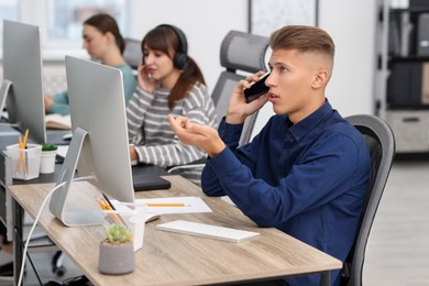 Photo of Sales department. People calling to clients in office, selective focus