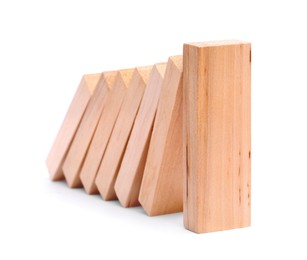 Photo of Domino effect. Wooden blocks falling on white background