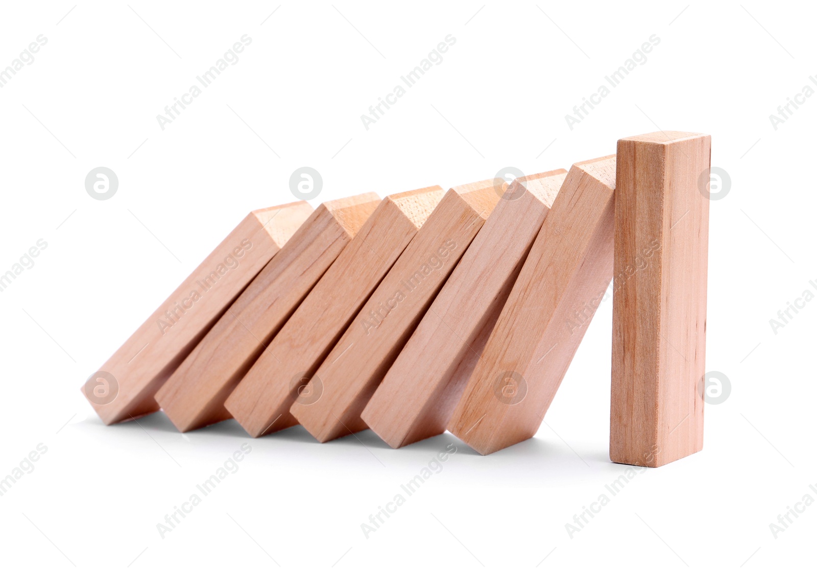 Photo of Domino effect. Wooden blocks falling on white background