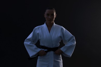 Photo of Silhouette of karate fighter in kimono on dark background