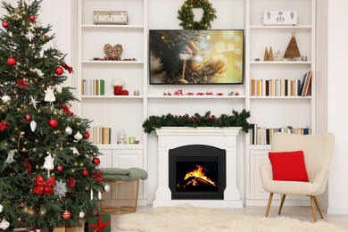 Beautifully decorated Christmas tree near fireplace in room. Festive interior design