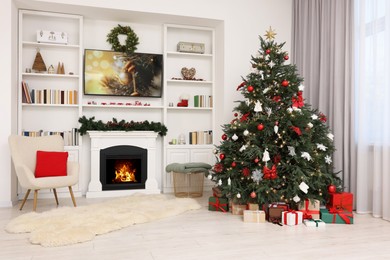 Photo of Beautifully decorated Christmas tree near fireplace in room. Festive interior design