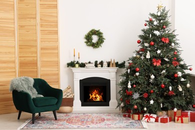 Decorated Christmas tree near fireplace in room. Festive interior design