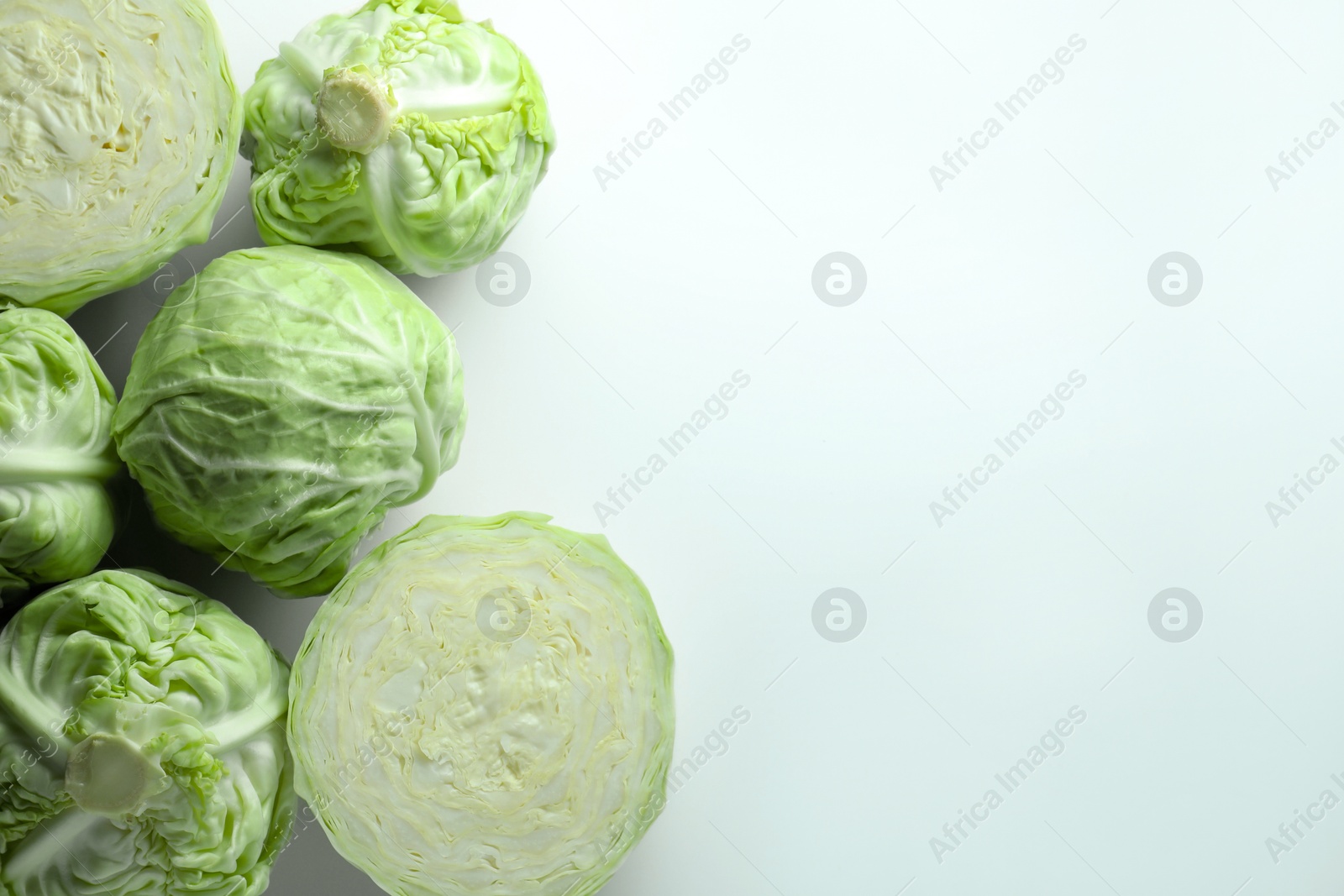 Photo of Raw green cabbages on white background, flat lay. Space for text