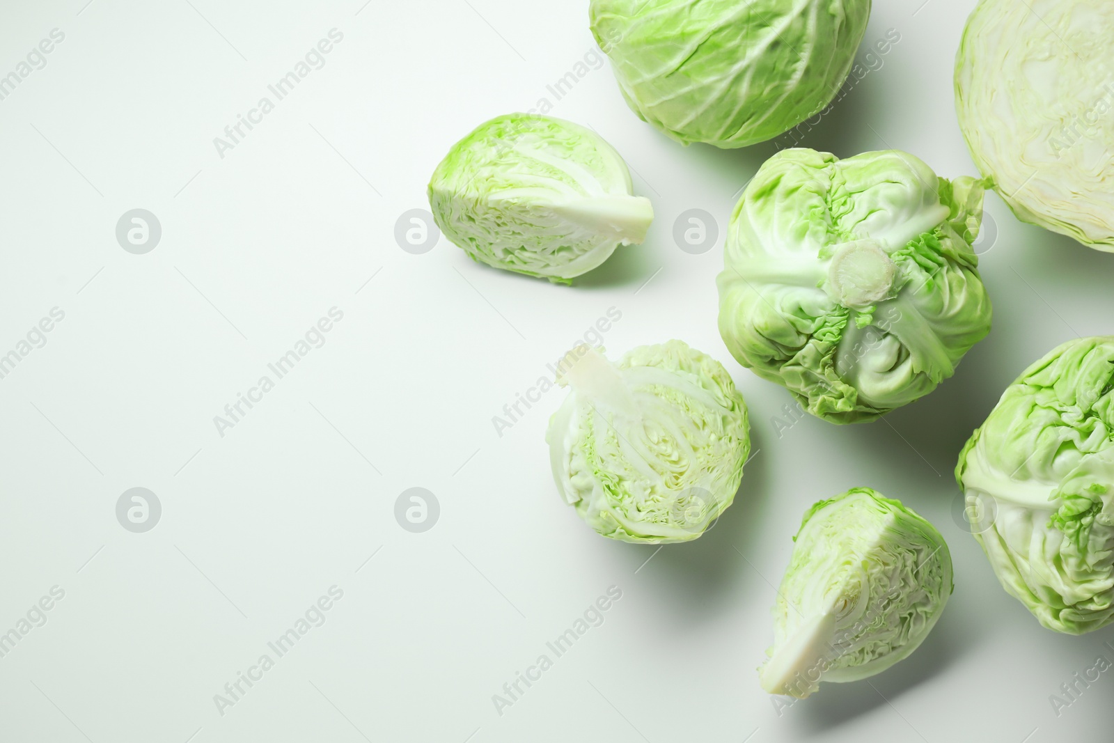 Photo of Raw green cabbages on white background, flat lay. Space for text