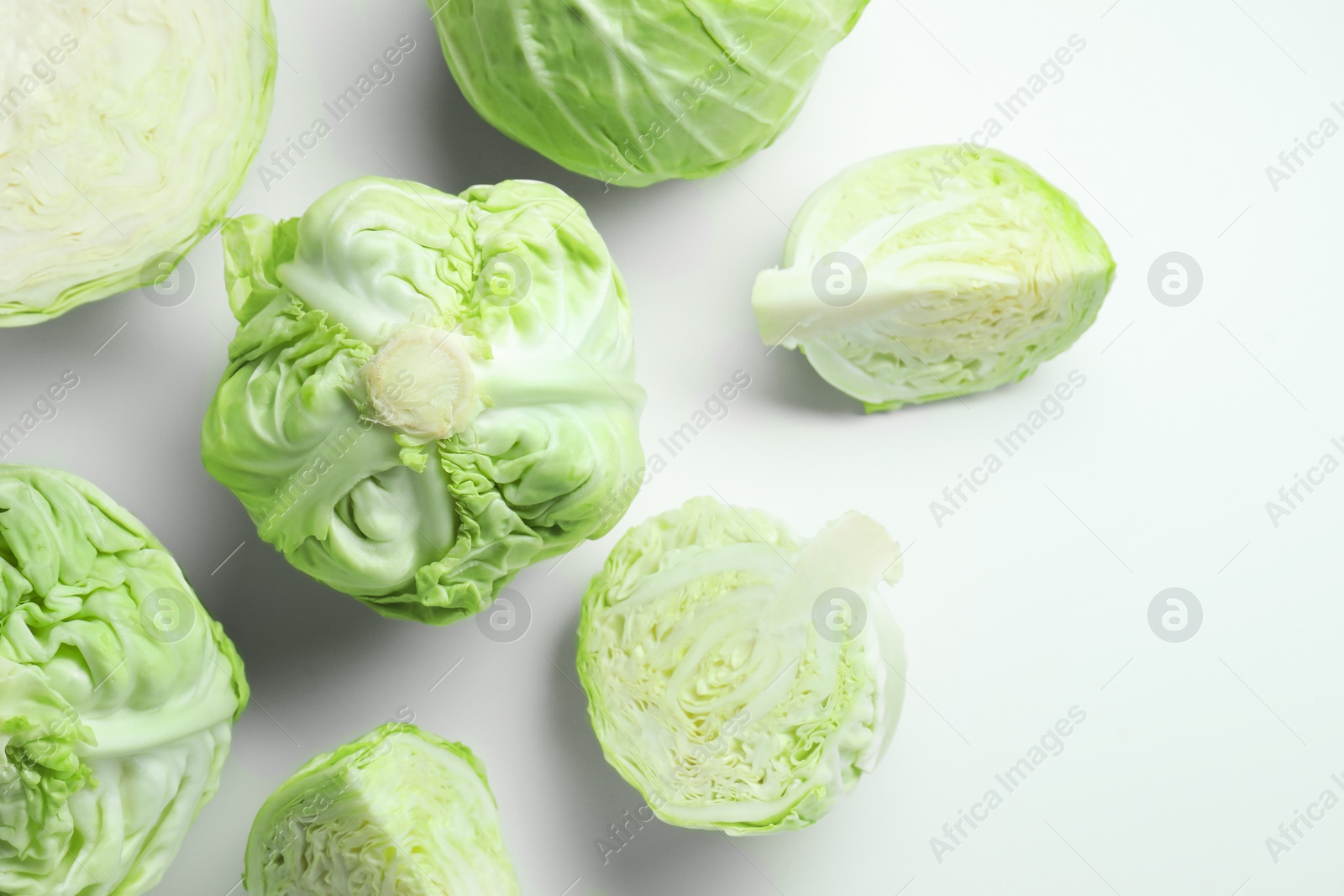 Photo of Raw green cabbages on white background, flat lay. Space for text