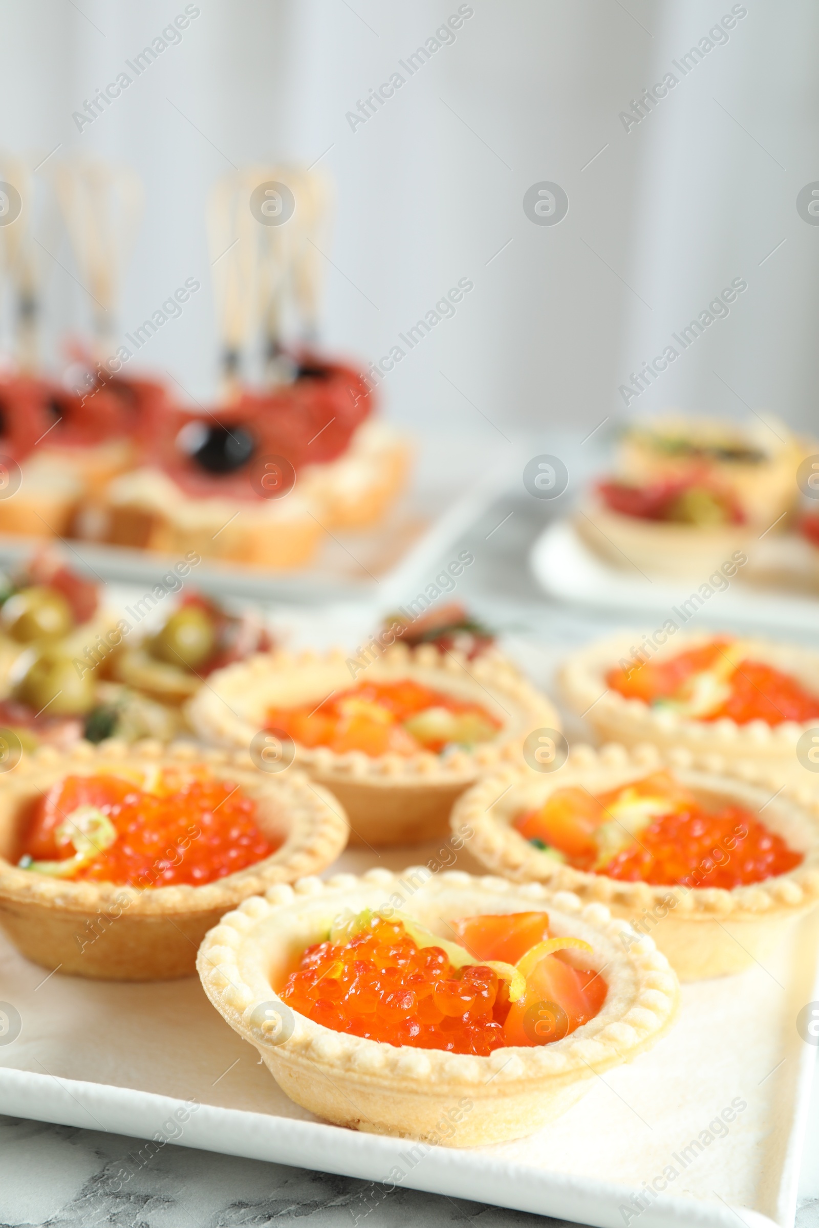 Photo of Many different tasty canapes on white marble table, closeup