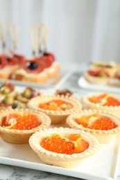 Photo of Many different tasty canapes on white marble table, closeup