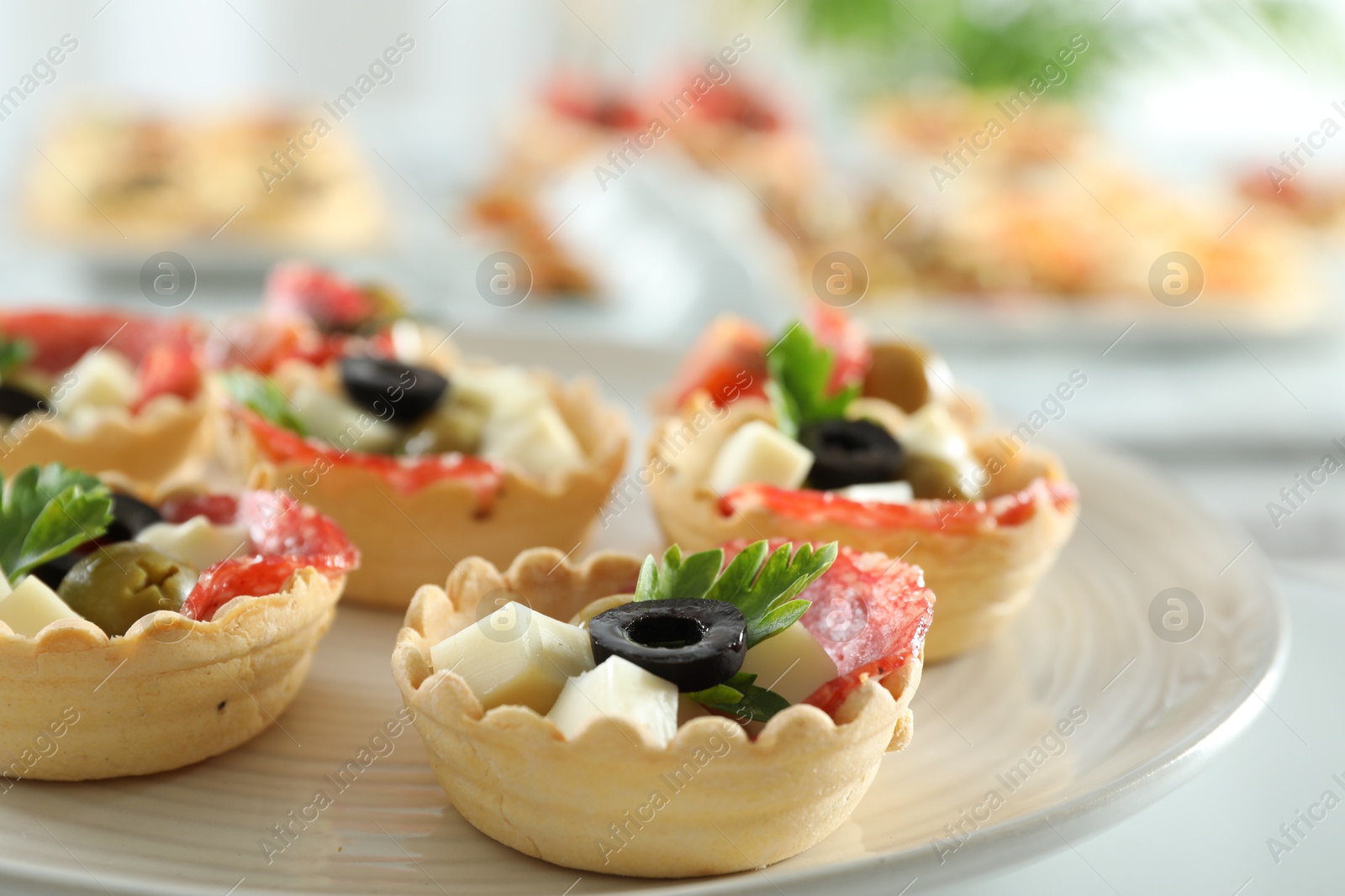 Photo of Many tasty canapes on white table, closeup