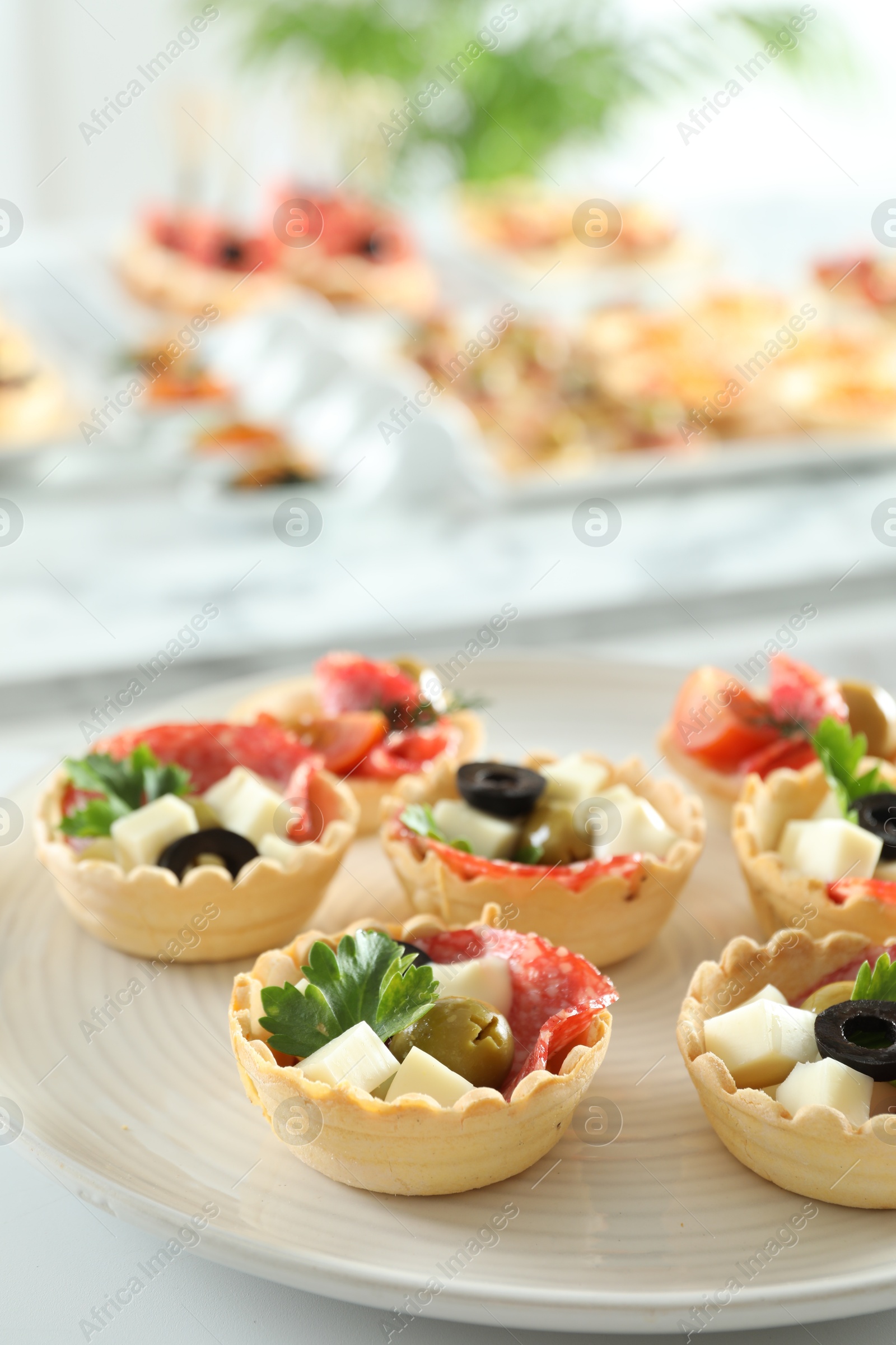 Photo of Many tasty canapes on white table, closeup