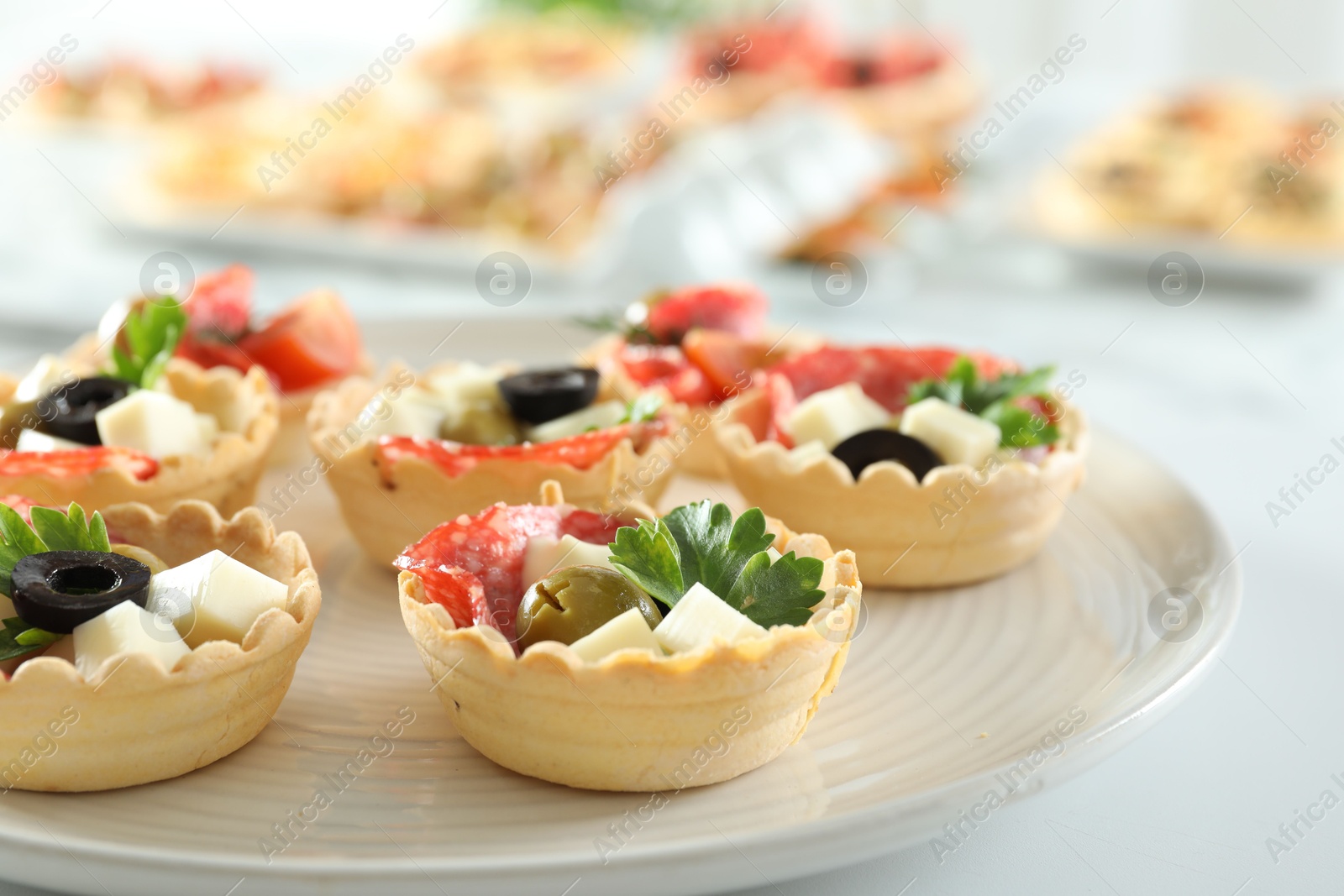 Photo of Many tasty canapes on white table, closeup