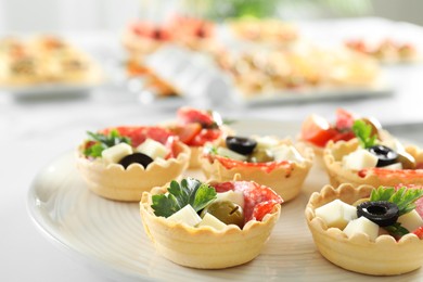 Photo of Many tasty canapes on white table, closeup