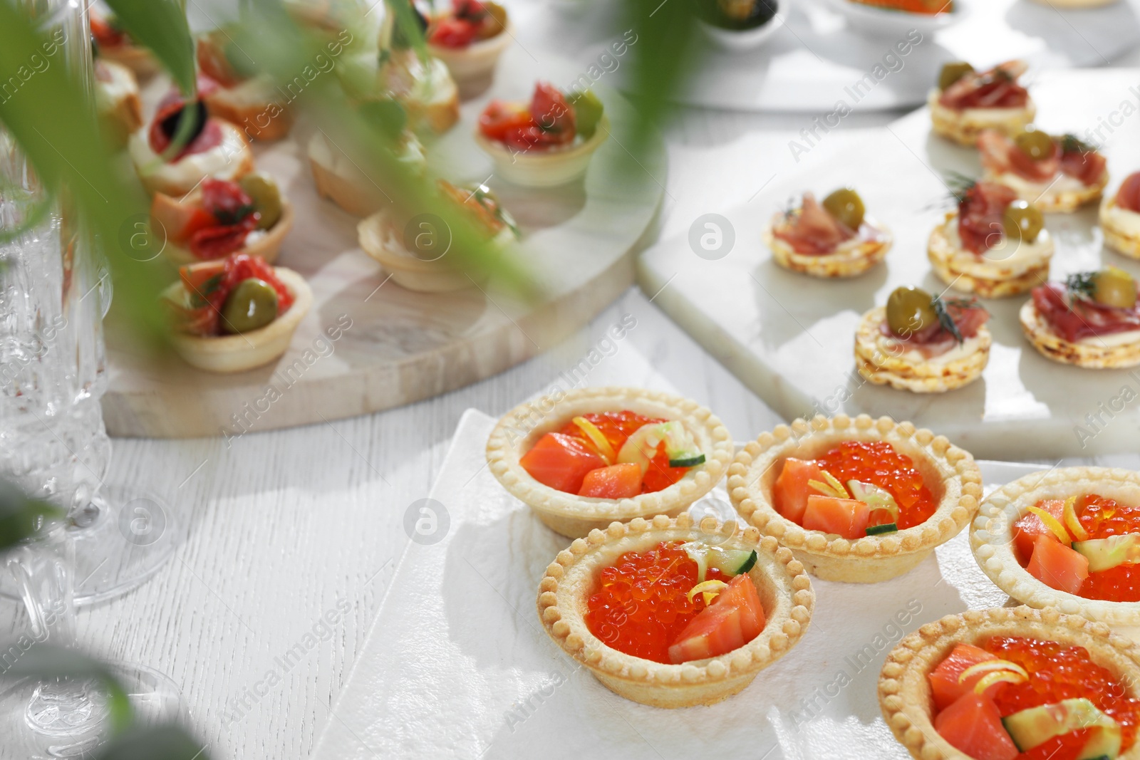 Photo of Many different tasty canapes on white wooden table, closeup