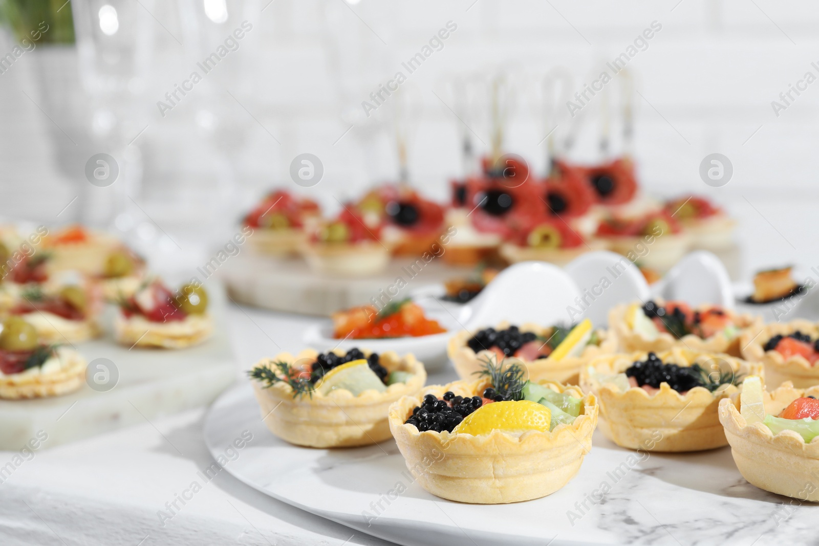 Photo of Many different tasty canapes on white wooden table, closeup