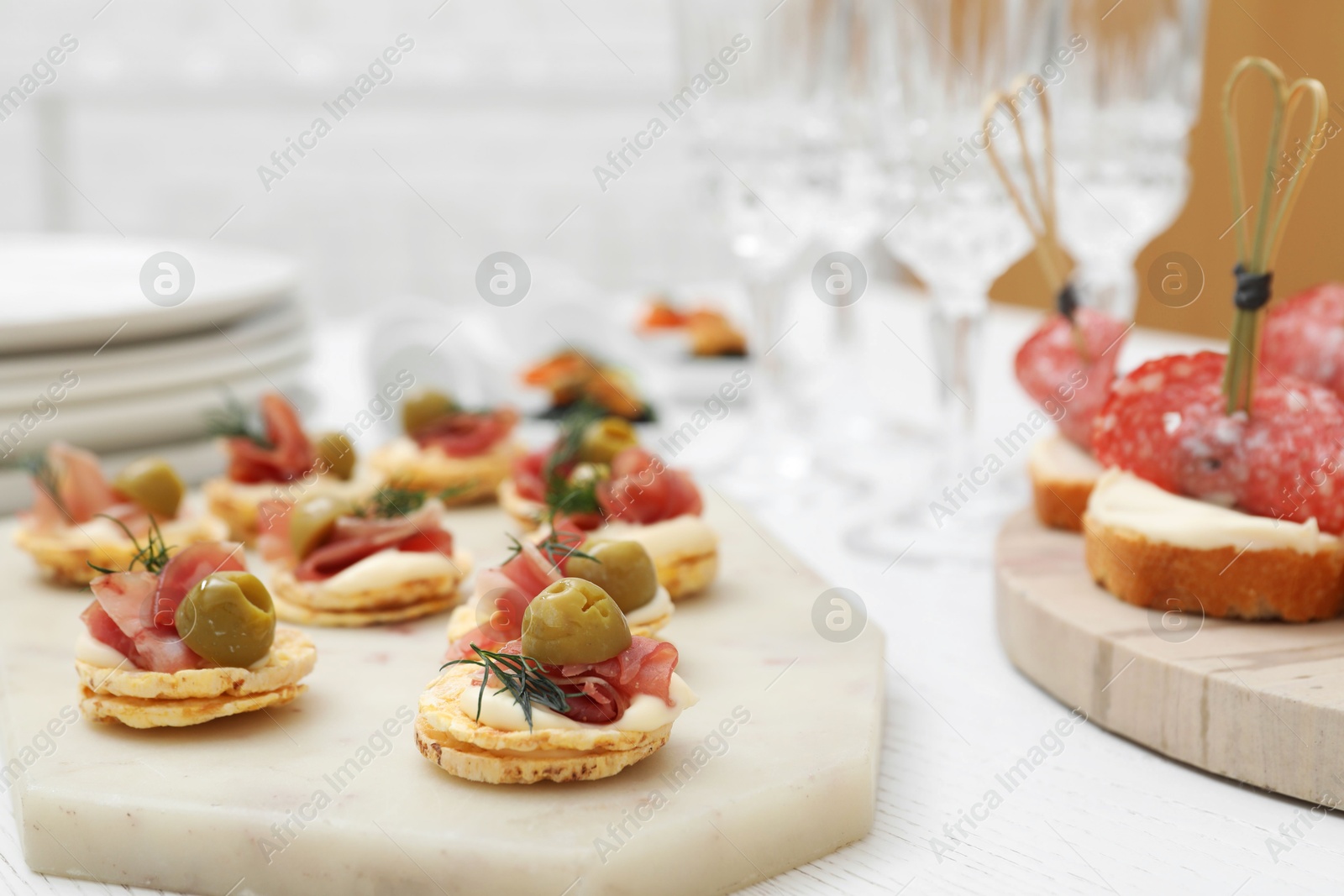 Photo of Many different tasty canapes on white wooden table, closeup