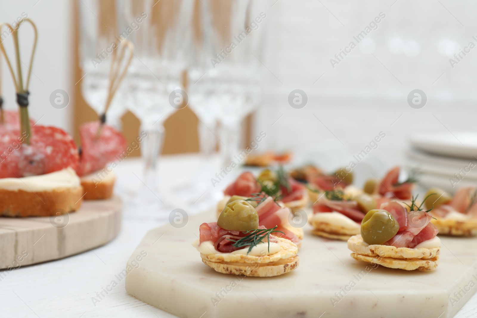 Photo of Many different tasty canapes on white wooden table, closeup