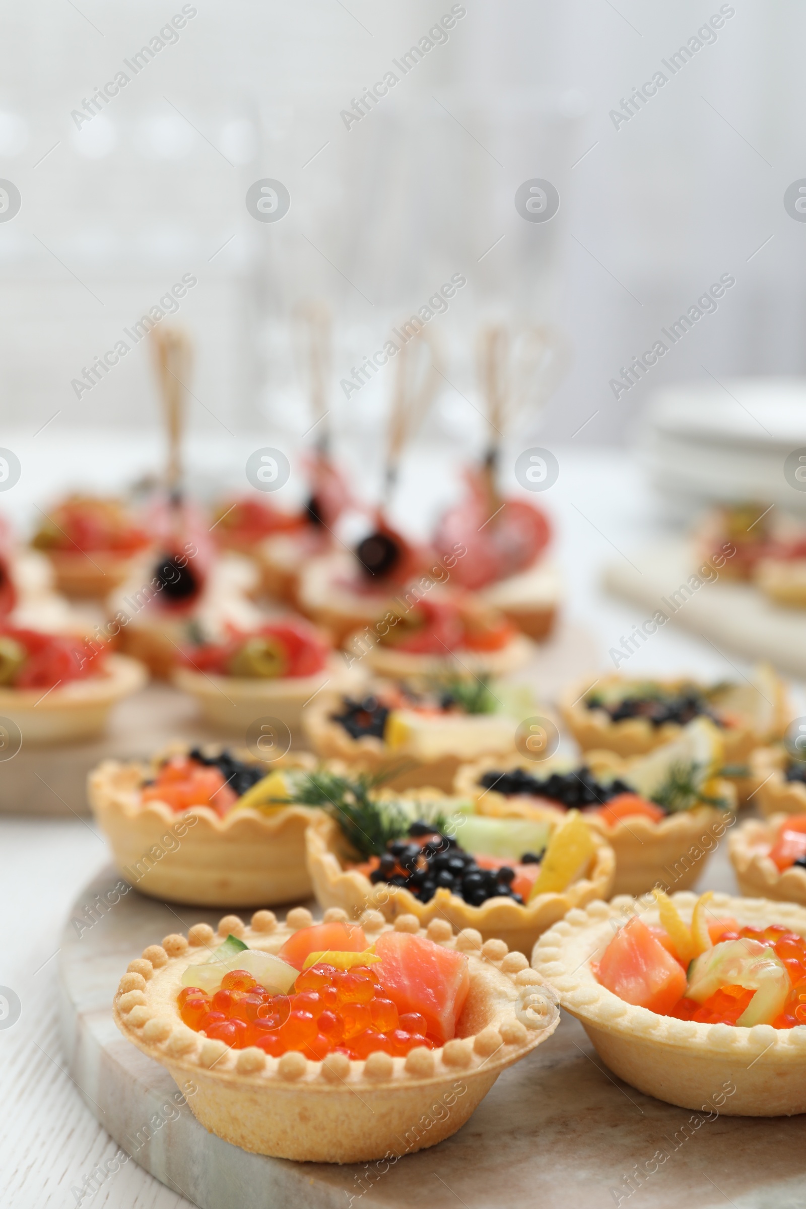 Photo of Many different tasty canapes on white wooden table, closeup