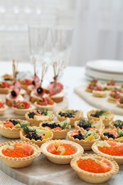 Photo of Many different tasty canapes on white wooden table, closeup