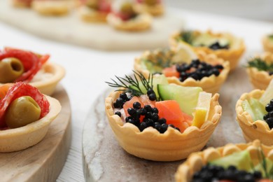 Photo of Many different tasty canapes on white wooden table, closeup