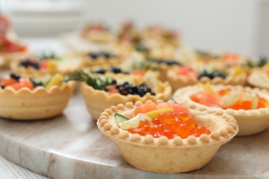 Photo of Many different tasty canapes on white wooden table, closeup