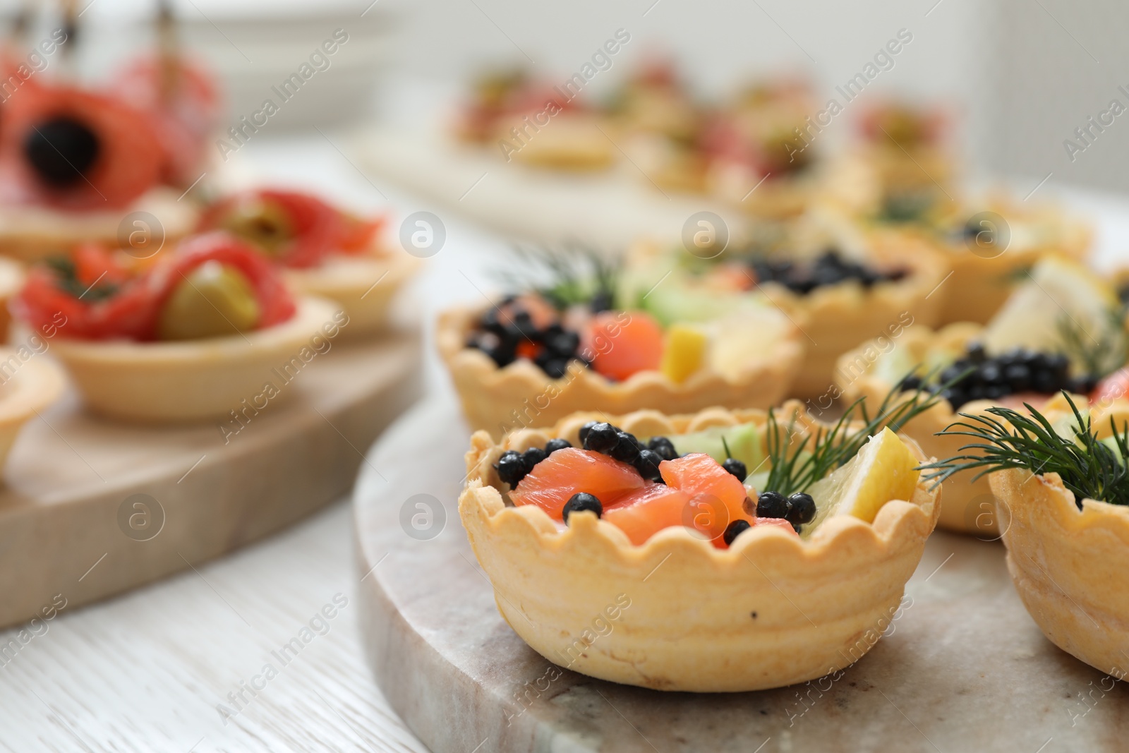 Photo of Many different tasty canapes on white wooden table, closeup