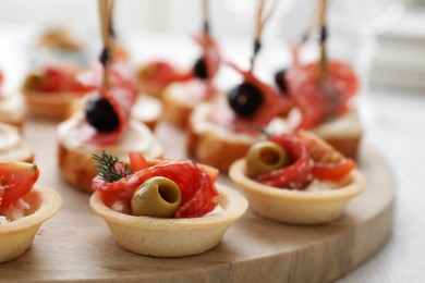 Photo of Many different tasty canapes on white wooden table, closeup