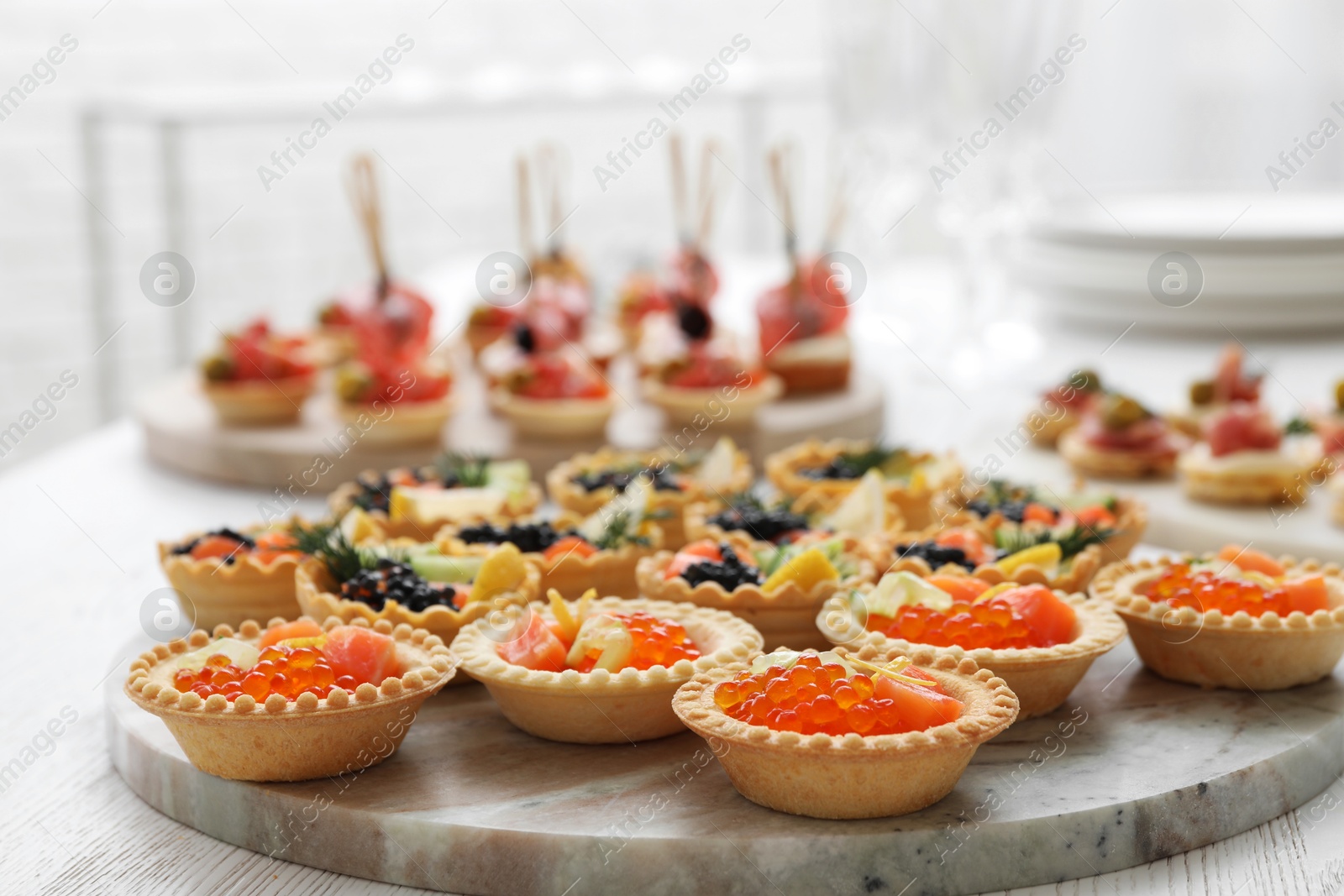 Photo of Many different tasty canapes on white wooden table, closeup